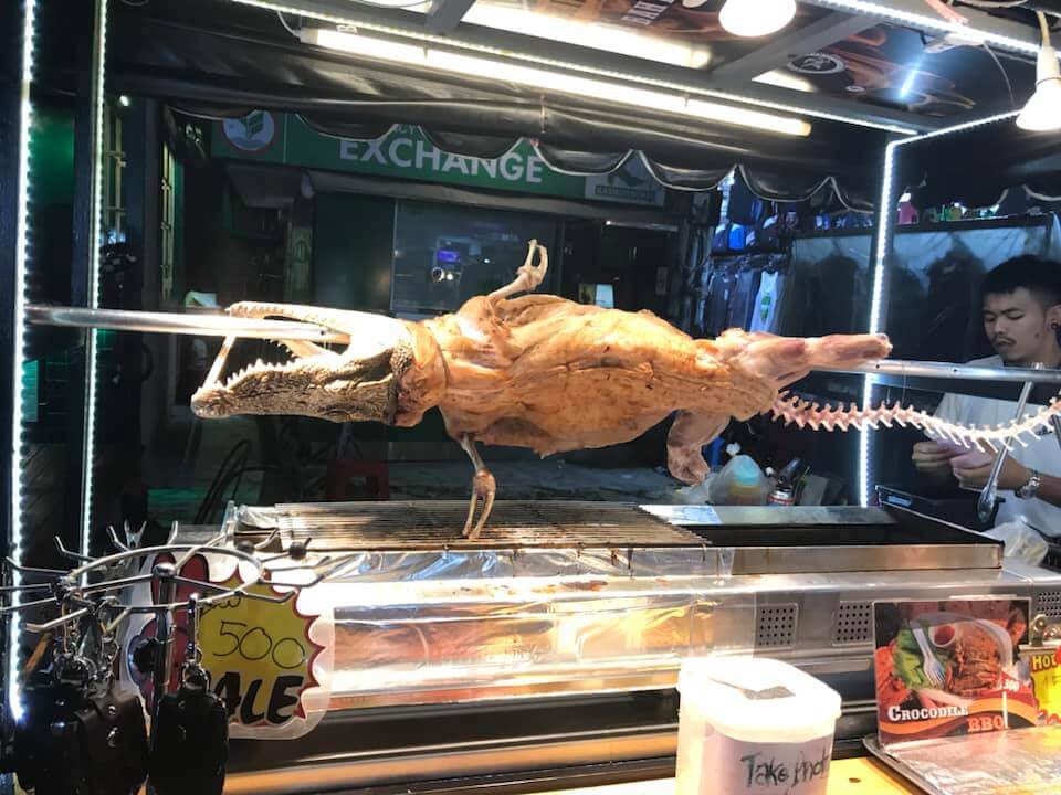 Alligator roasting on a spit on a food stand on Khao San Road in Bangkok, Thailand